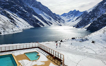 Laguna del Inca with snow-covered mountains and a lakeside pool in Chile.
