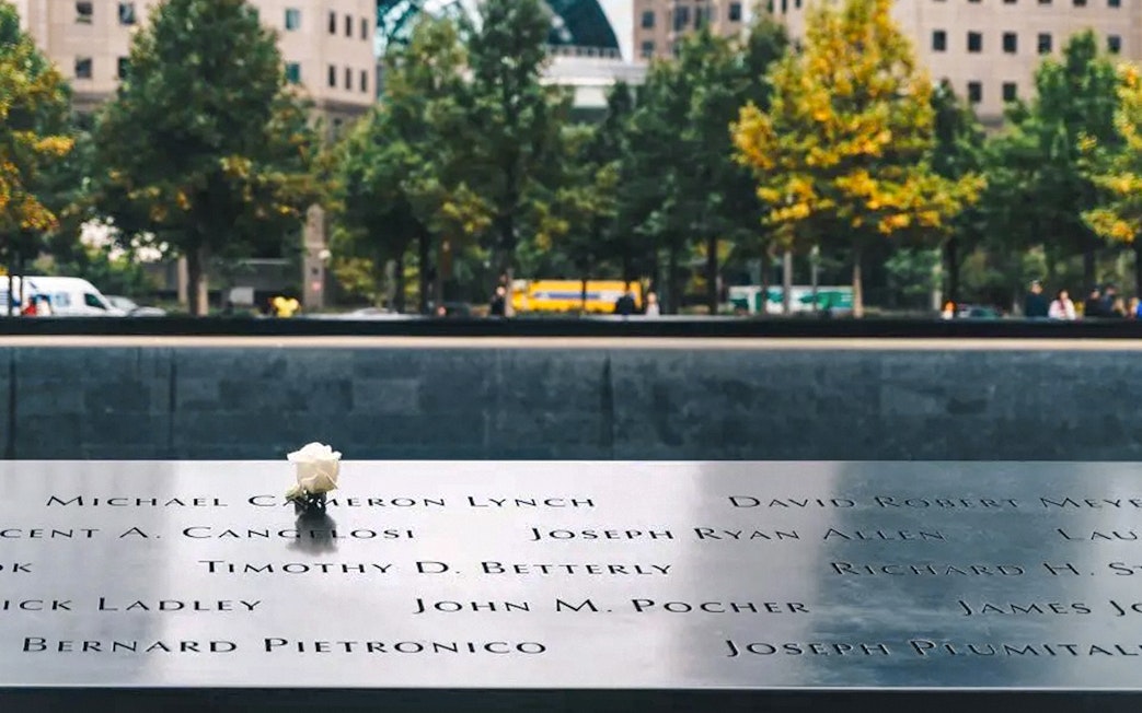 Names engraved on the 9/11 Memorial with a white rose, New York City.