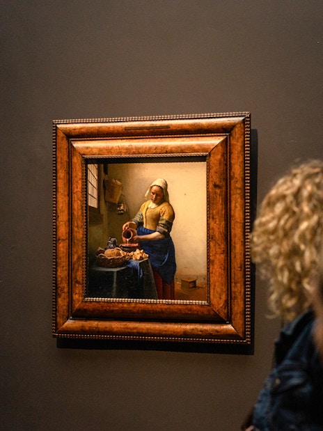 Visitors viewing Vermeer's "The Milkmaid" at the Rijksmuseum in Amsterdam.