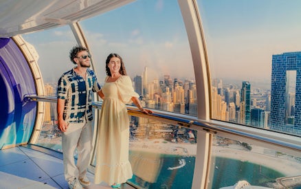 Visitors enjoying the view inside Ain Dubai with city skyline in the background.