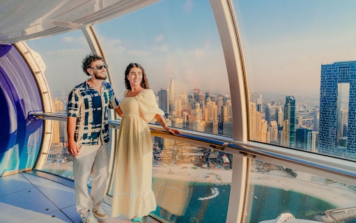 Visitors enjoying the view inside Ain Dubai with city skyline in the background.