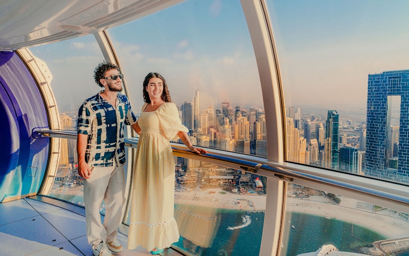 Visitors enjoying the view inside Ain Dubai with city skyline in the background.