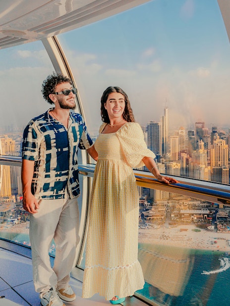 Visitors enjoying the view inside Ain Dubai with city skyline in the background.