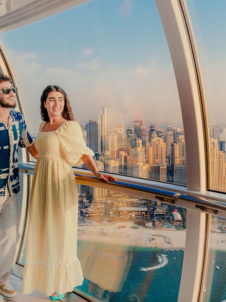 Visitors enjoying the view inside Ain Dubai with city skyline in the background.