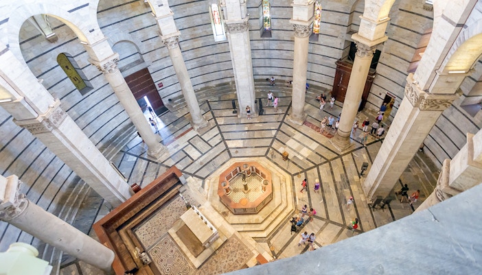 Circular interior of St. John's Baptistery in Pisa with intricate architectural details.
