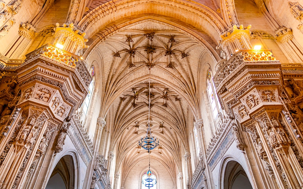 Gothic interior of Toledo Cathedral with ornate arches and detailed carvings.
