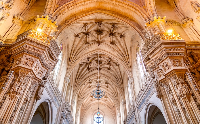 Gothic interior of Toledo Cathedral with ornate arches and detailed carvings.