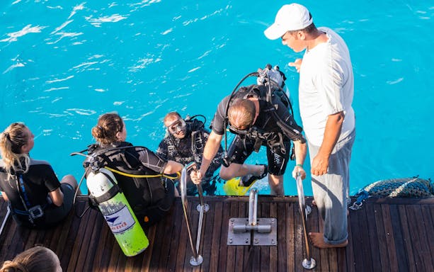Divers preparing to enter the Mediterranean Sea from a boat.