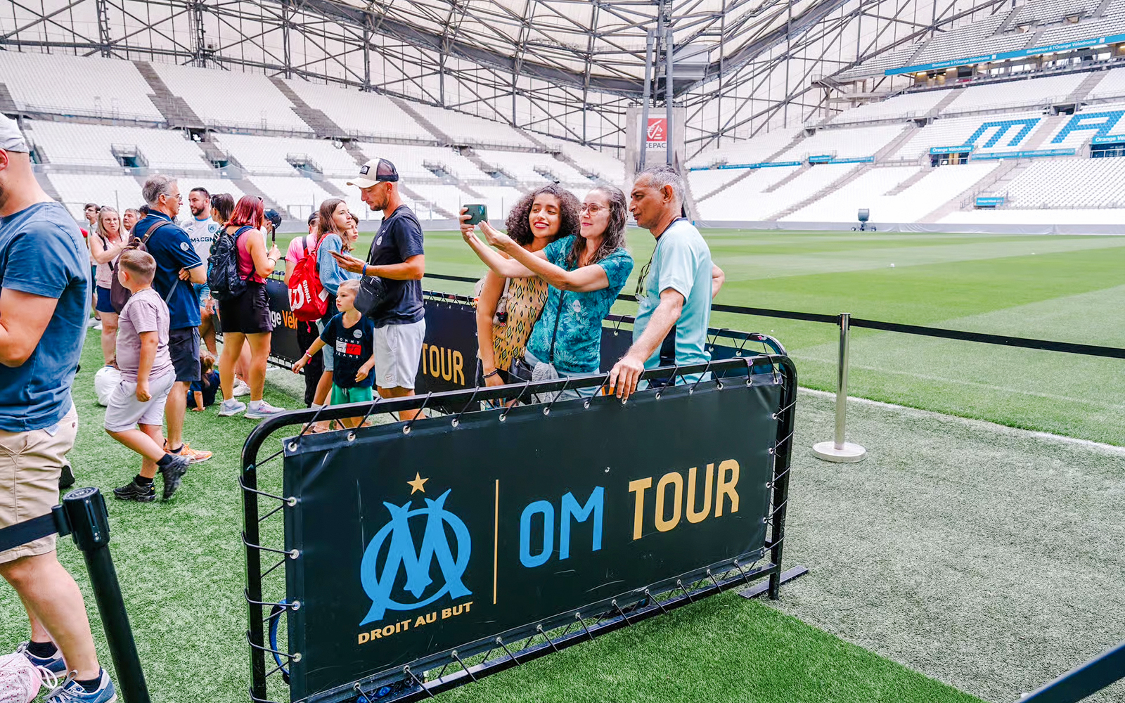 Visitors taking a selfie during a Velodrome stadium tour in Marseille.