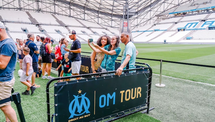 Visitors taking a selfie during a Velodrome stadium tour in Marseille.
