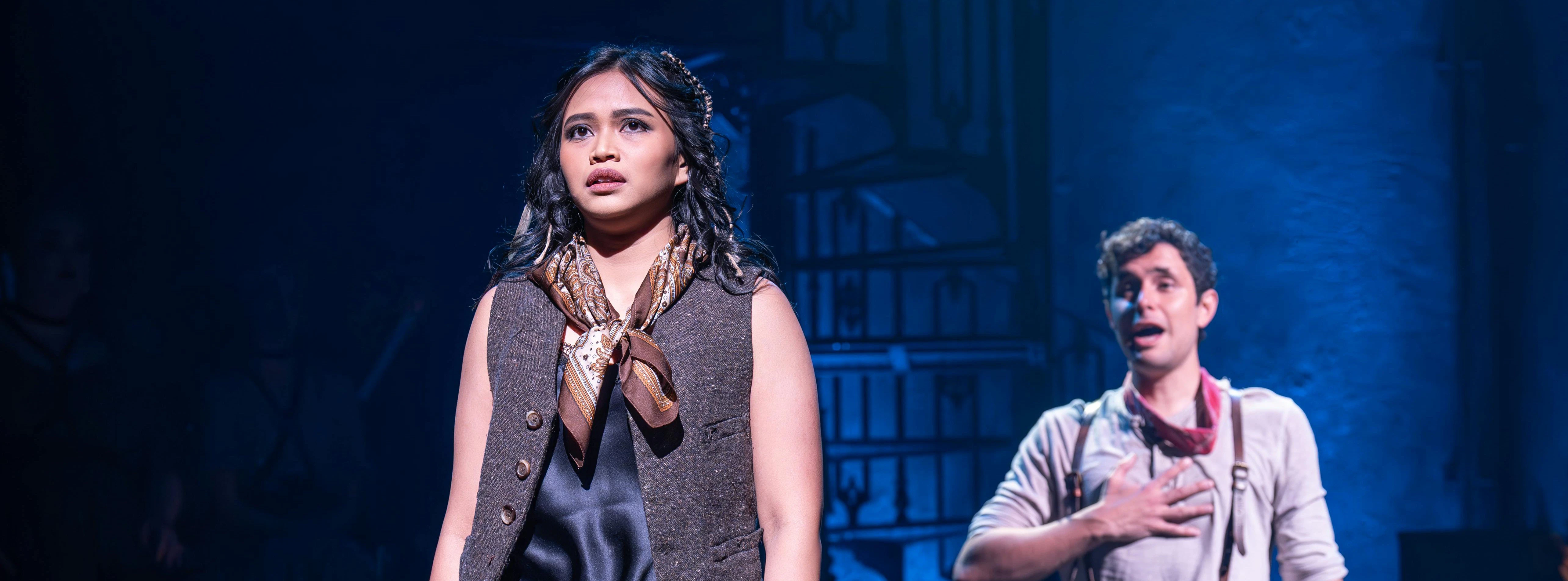 Actors performing a scene from Hadestown on West End stage.