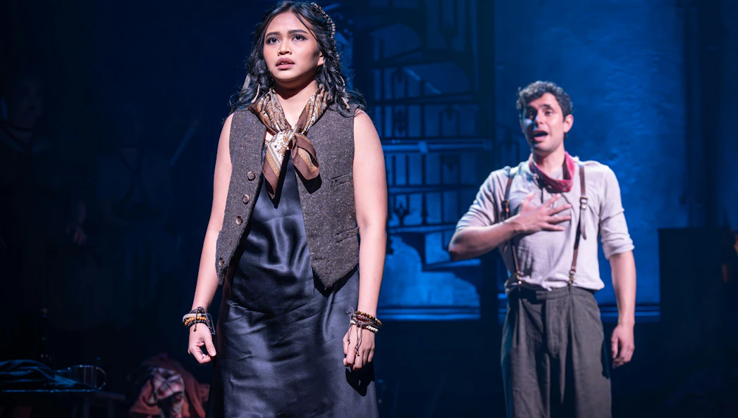 Actors performing a scene from Hadestown on West End stage.