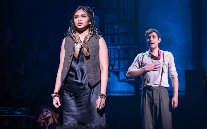 Actors performing a scene from Hadestown on West End stage.