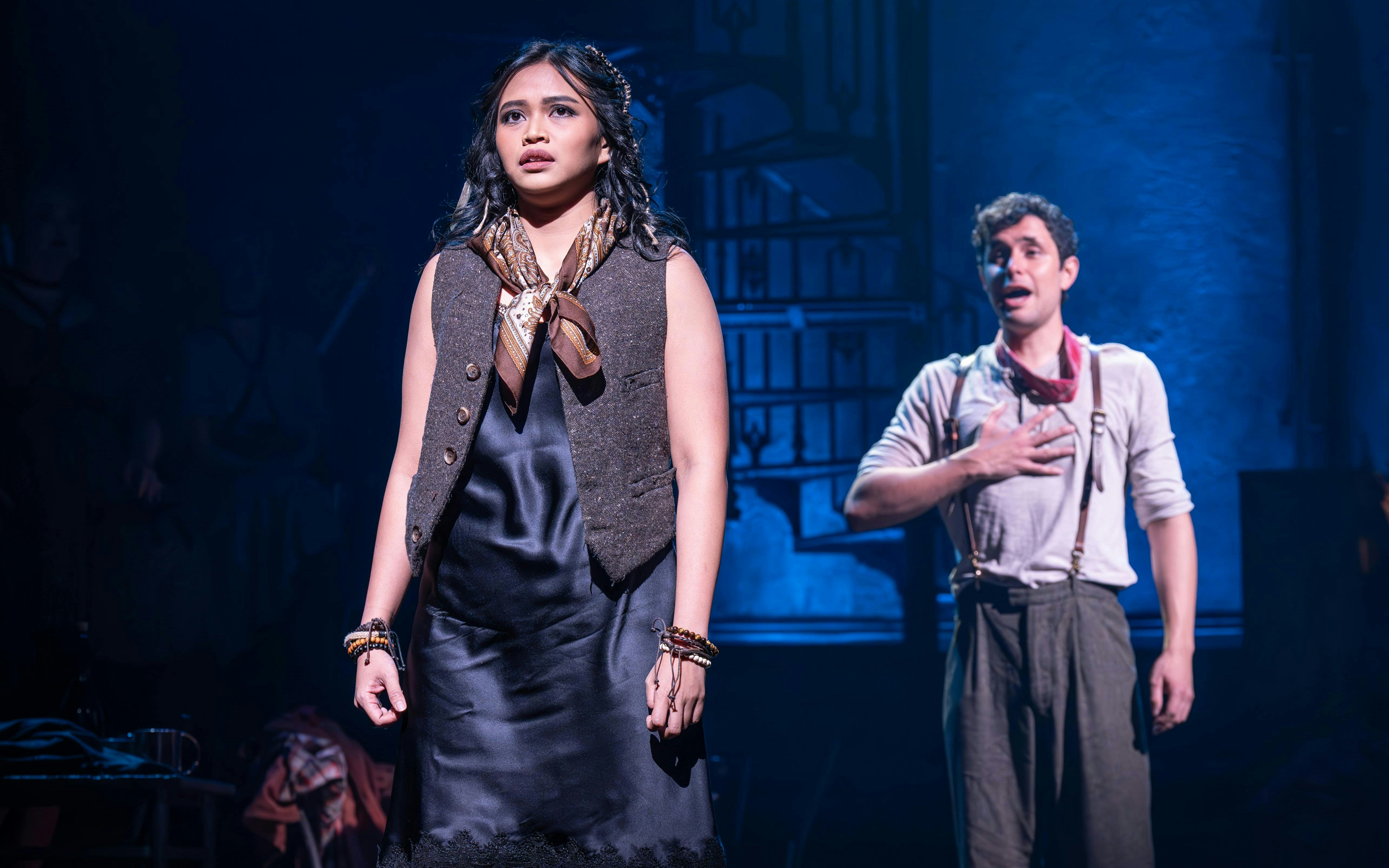 Actors performing a scene from Hadestown on West End stage.