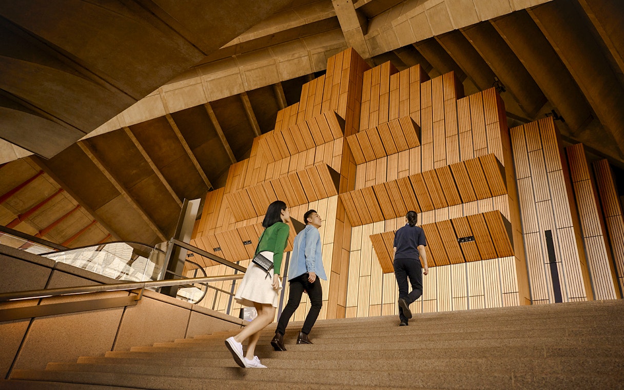Visitors ascending steps inside Sydney Opera House during a guided tour.