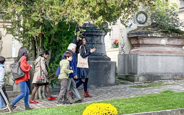 Group touring Père Lachaise Cemetery with guide in Paris.