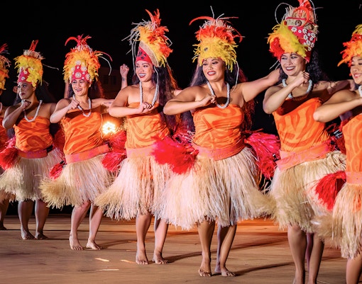 Performers dancing in traditional attire at Mauka Warriors Luau cultural night show.