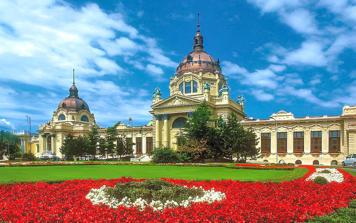Szechenyi Bath exterior with ornate yellow facade and domed roof in Budapest, Hungary.