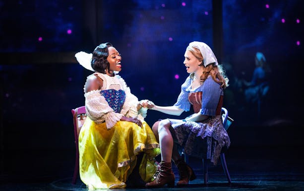 Two performers in costume holding hands on stage during "Once Upon a One More Time" musical.