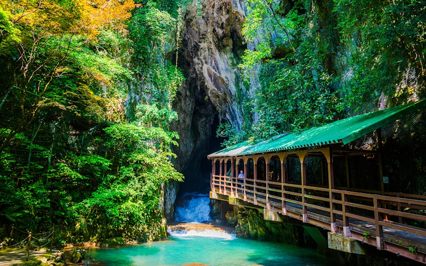 Entrance of a limestone cave with a wooden bridge, Plitvice Lakes National Park.