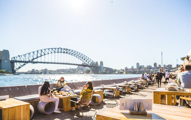 Sydney Opera House tour guests dining with view of Harbour Bridge.