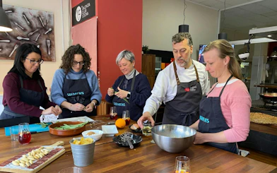 Participants preparing ingredients during a paella-making class in Valencia cooking school.