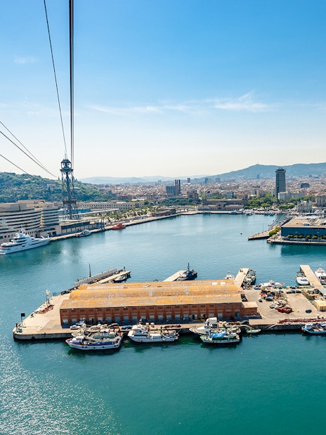 Montjuic cable car view over Barcelona harbor and cityscape.
