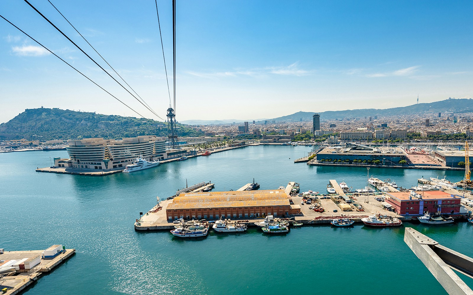 Montjuic cable car overlooking Barcelona cityscape and coastline.