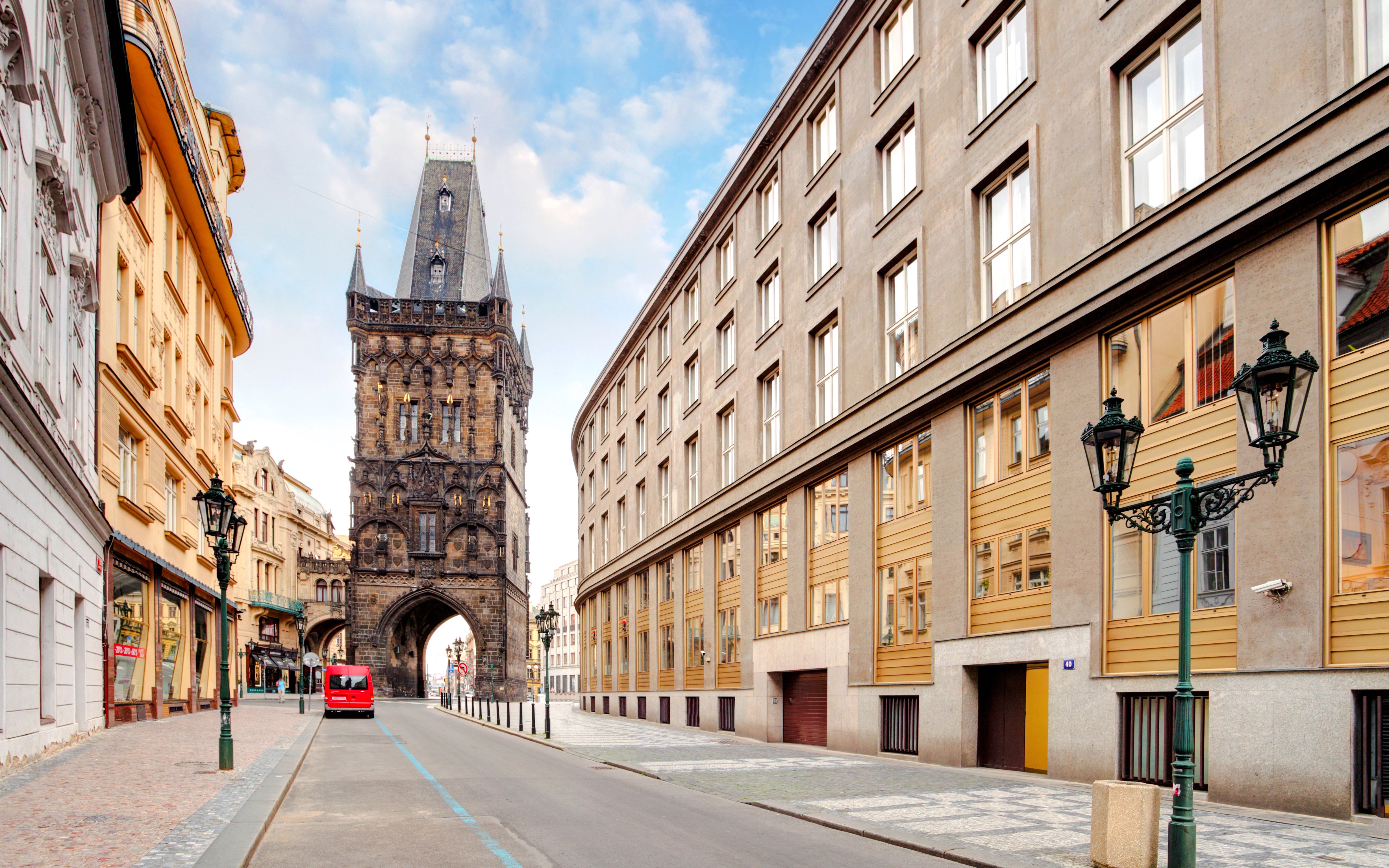 Powder Tower in Prague with surrounding historic buildings and a street view.