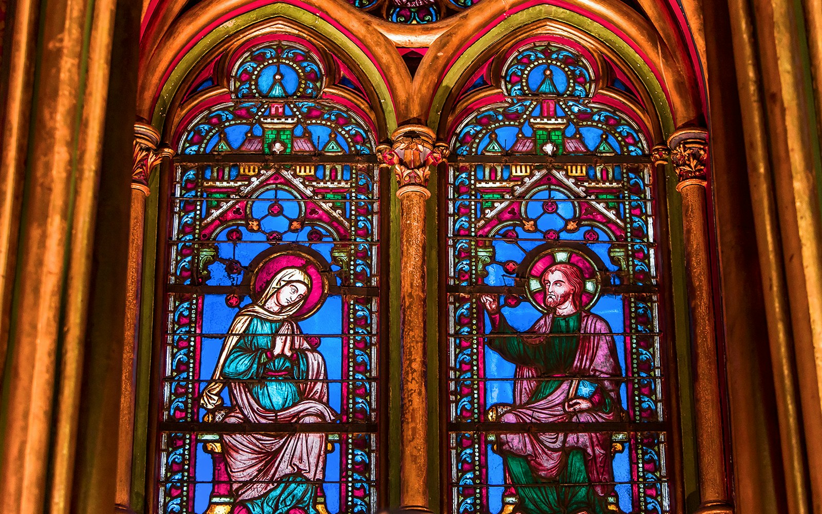 Sainte Chapelle stained glass windows in Paris showcasing intricate biblical scenes.