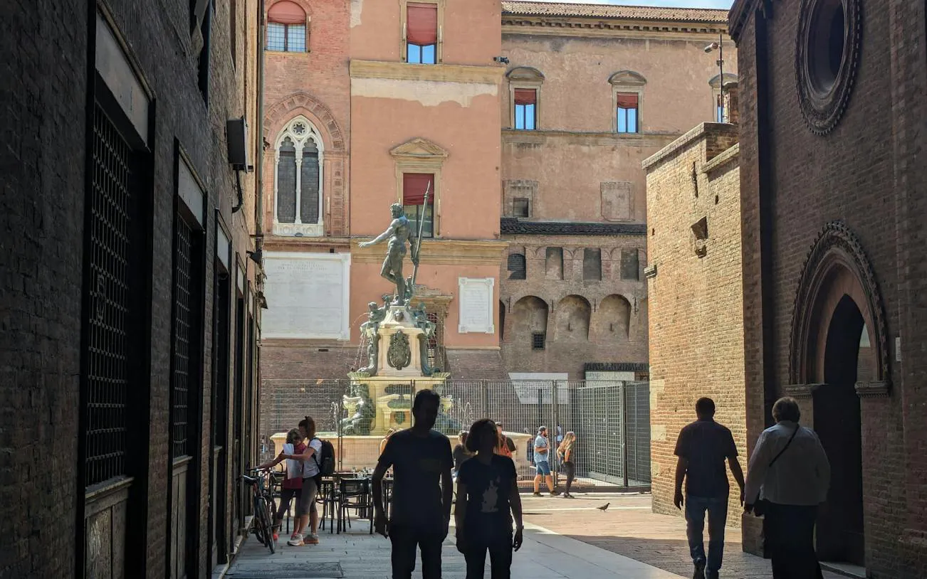 People walking towards the Fountain of Neptune in Bologna during a city exploration game.