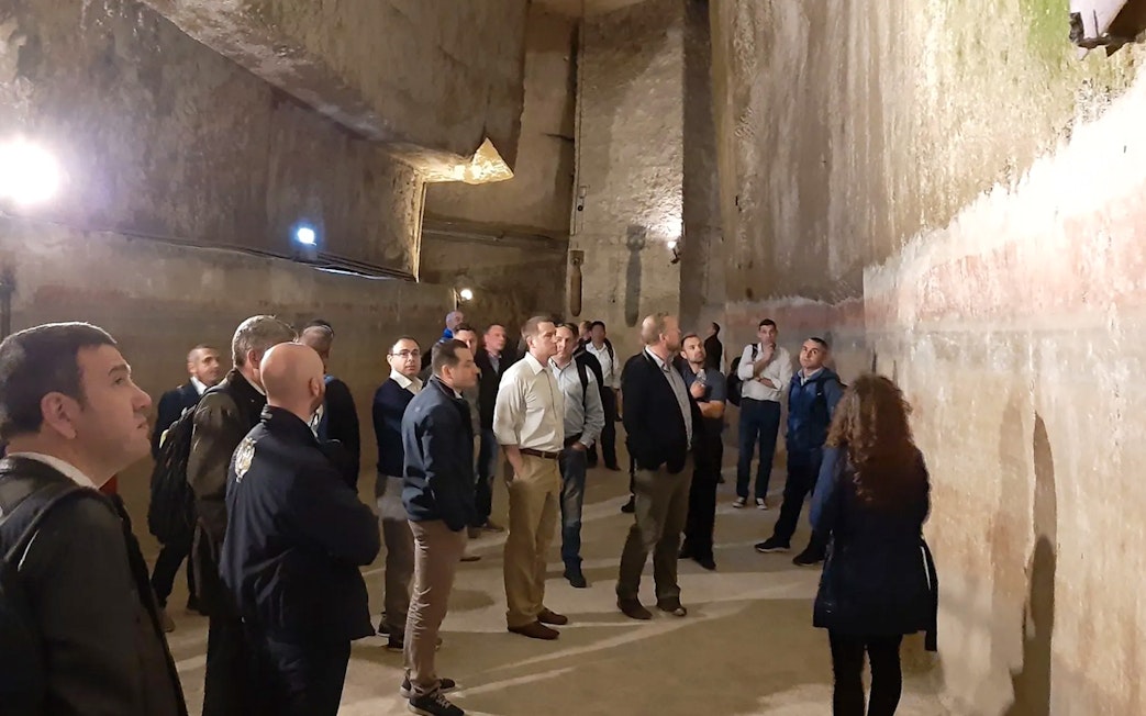 Group touring ancient tunnels in Naples Underground.