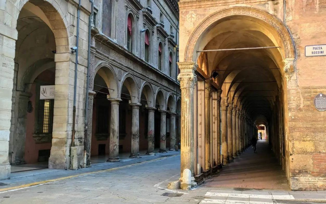 Bologna's Piazza Rossini with historic porticoes, part of the self-guided murder mystery city exploration game.