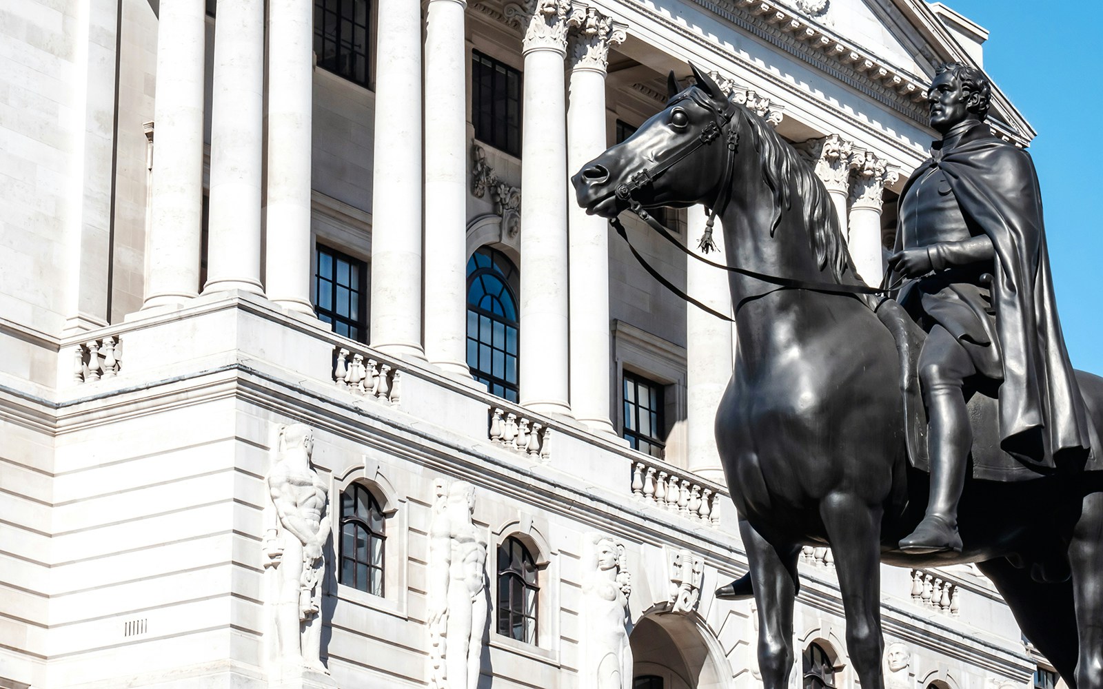 Statue of the Duke of Wellington on horseback in front of a neoclassical building.