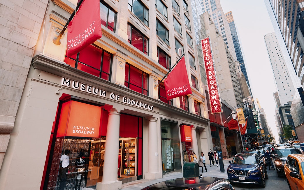 Museum of Broadway entrance with visitors on a busy New York City street.