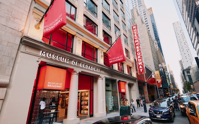 Museum of Broadway entrance with visitors on a busy New York City street.