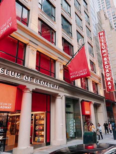 Museum of Broadway entrance with visitors on a busy New York City street.