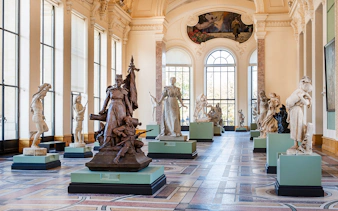 Sculpture gallery inside Petit Palais, Paris, featuring classical statues and ornate architecture.