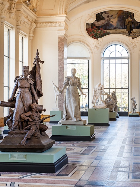 Sculpture gallery inside Petit Palais, Paris, featuring classical statues and ornate architecture.