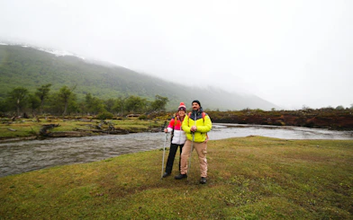 Trekking couple by river near Vinciguerra Glacier, Ushuaia.