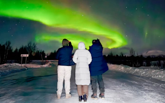 Small group watching northern lights in Kiruna, Sweden.