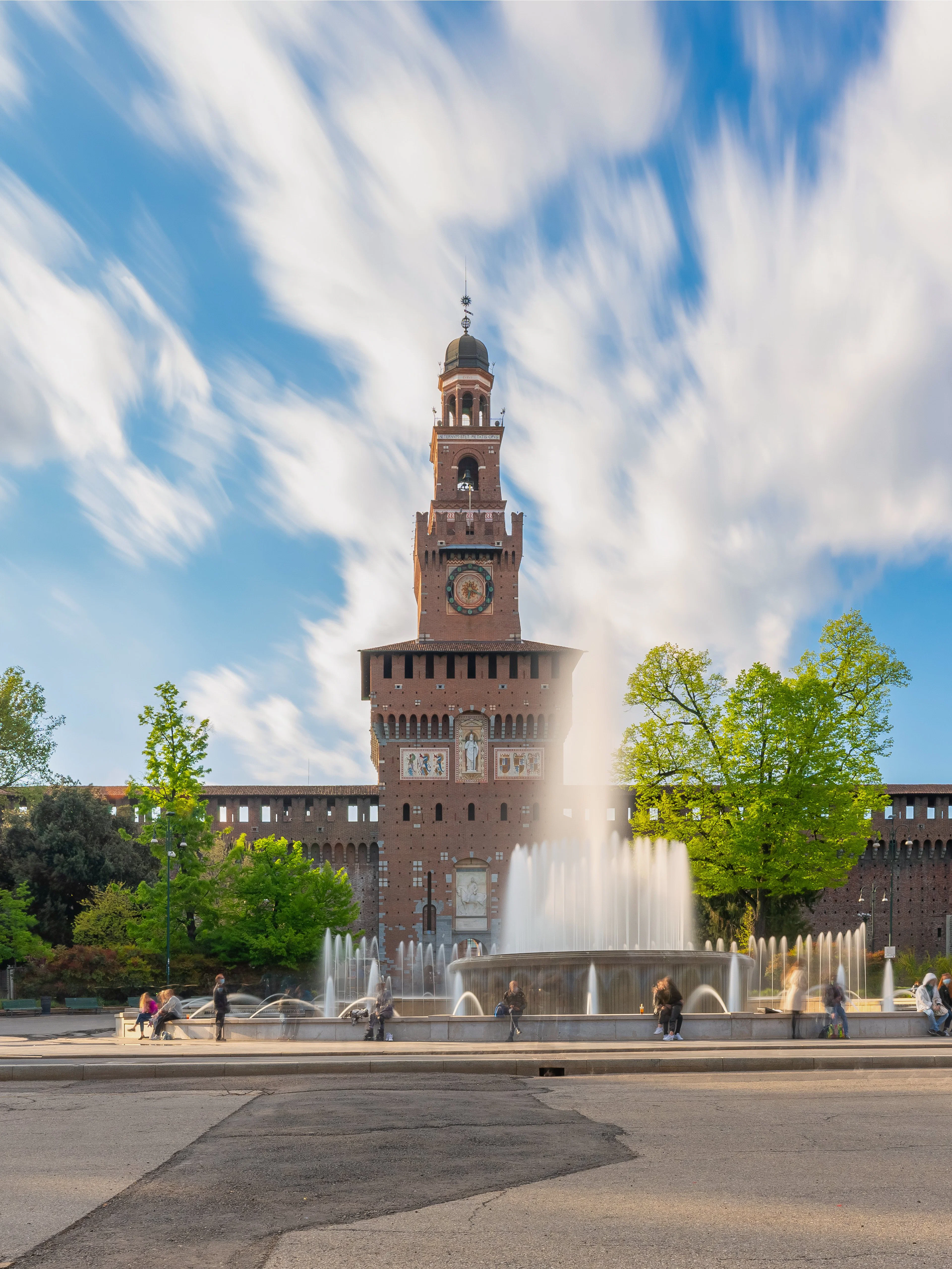 Sforza Castle in Milan with central tower and fountain in foreground.