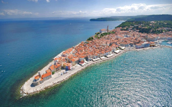 Aerial view of Piran Town, Slovenia, featuring coastal buildings and the Adriatic Sea.