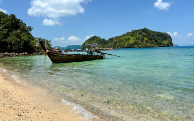 Longtail boat anchored near Hong Islands, Krabi, with clear water and lush greenery.