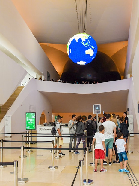 Tourists queue at the entrance of the Aquário Aquarium, featuring a globe display.