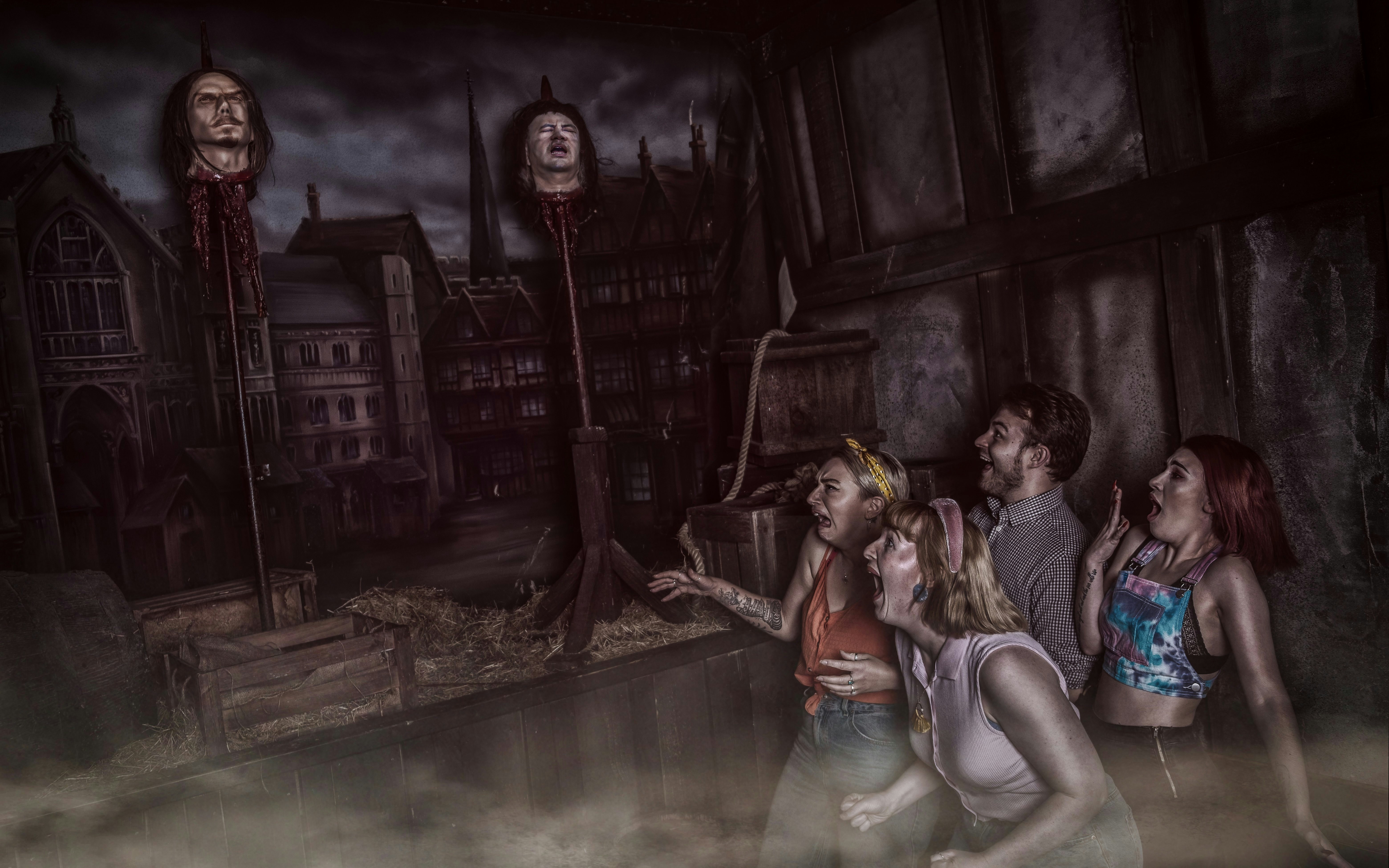 Visitors react to Guy Fawkes exhibit at York Dungeon with historical backdrop.