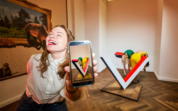 Visitors interacting with optical illusion exhibit at IAM Illusion Art Museum, Prague.