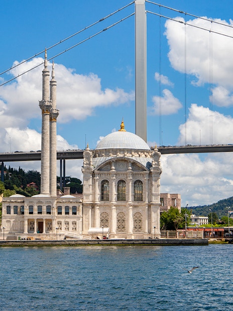 Ortaky Mosque with white stone architecture and twin minarets by the Bosphorus Bridge, Istanbul.
