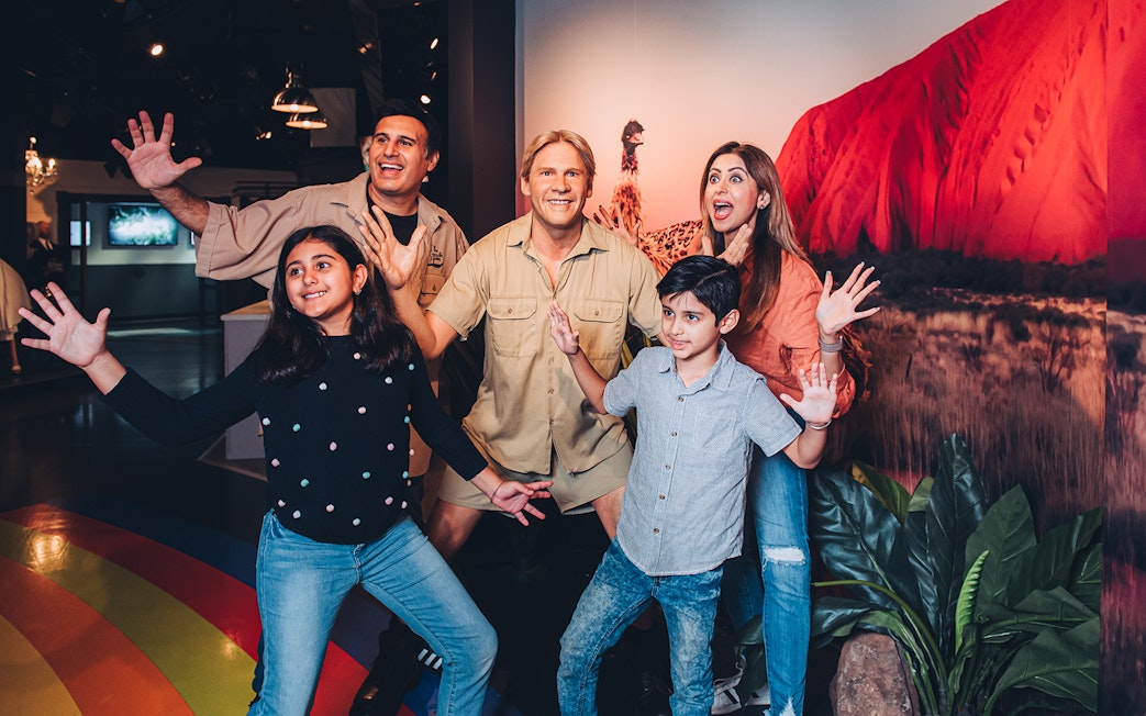 Family posing with wax figure at Sydney attraction, part of Multi Attraction Pass.
