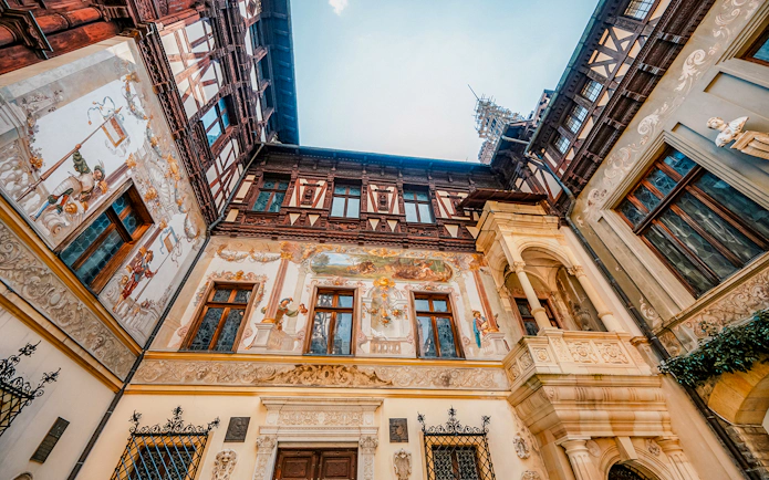 Inner courtyard walls of Peles Castle with detailed frescoes and ornate architecture.